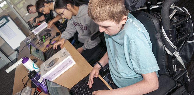 A group of students with diverse abilities work in a computer lab