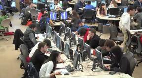 
Still image from video: Students working in a large open computer lab