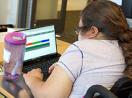 A student in a wheelchair uses a laptop.