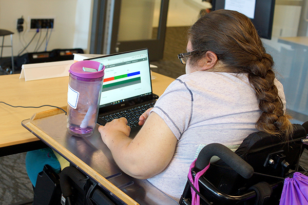 A woman uses a computer in a classroom