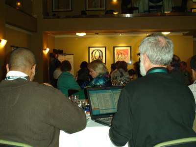 People working on laptops while listening to a presentation at a conference