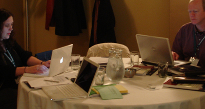 Two adults using computers at a conference