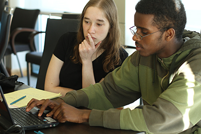 Teacher assisting a student on the computer