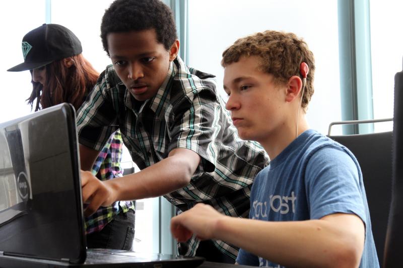 Two students working on a computer together.