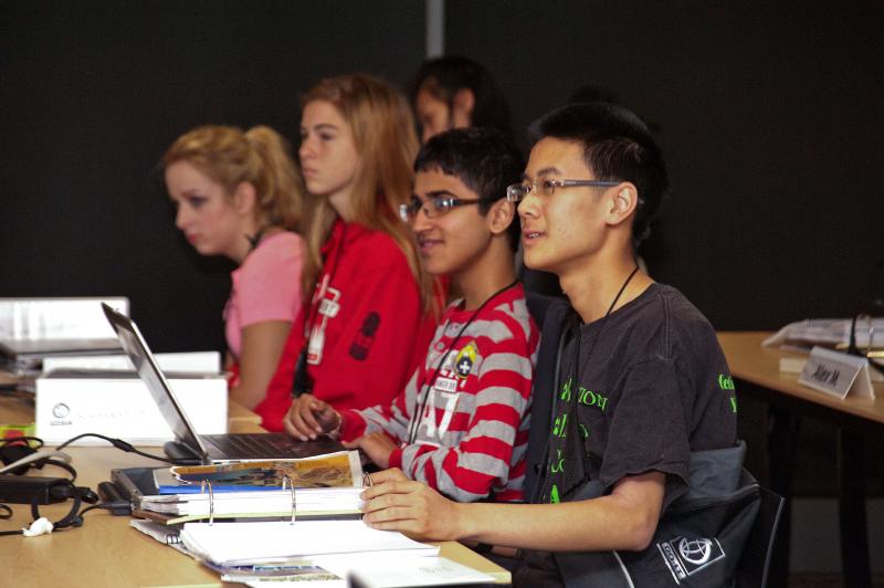 Four students using computer technology.