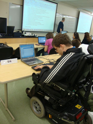 Image of AccessComputing student using accessible technology during a lecture for story.