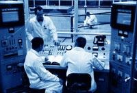 Scientists work the control boards for the new reactor. Photo by James Sneddon, courtesy of UW Libraries, Special Collections, Info Services S-7051-1.