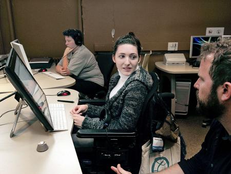 Image of a student working with an instructor in a computer lab.