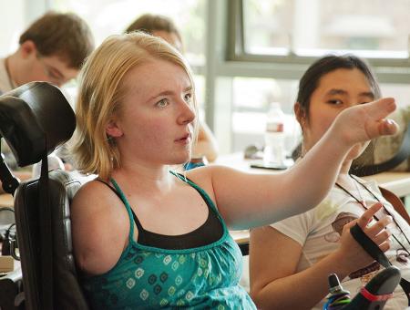 Image of a student raising her hand during a classroom activity.