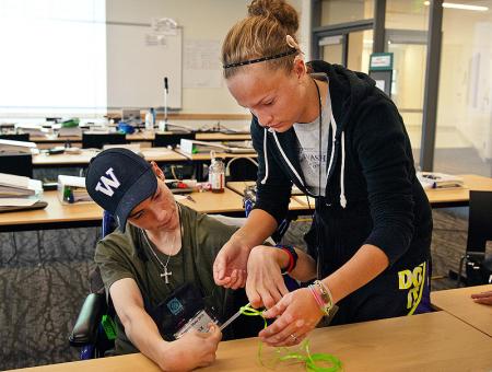 Image of two students working together to construct a kite.