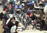 Still image from video: Students working in a large open computer lab