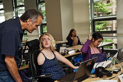 A DO-IT Staff member helps students with their computers.