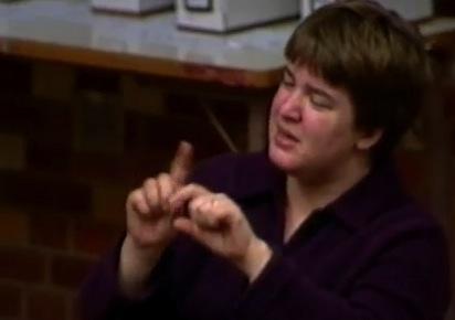 still image from video Building Team 1 showing woman using sign language