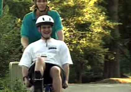 still image from video Camp showing two male individuals using an adaptived bicycle