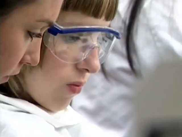 Still image from video STEM RDE showing DO-IT Scholar performing a science experiemnt with help from another woman