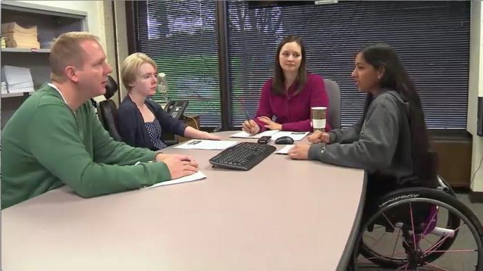 Still image from video: A diverse group of individuals meets around a large table