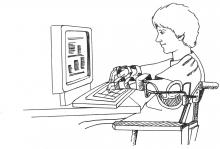 A student with arm braces working on a computer.