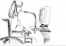 Woman using wheelchair and mouthpiece accessible technology to use computer.