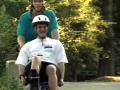 still image from video Camp showing two male individuals using an adaptived bicycle