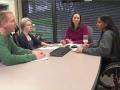 Still image from video: A diverse group of individuals meets around a large table