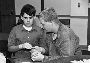 Eric takes part in an experiment in science, assisted by Lloyd Picture of DO-IT Scholars taking part in a science experiment
