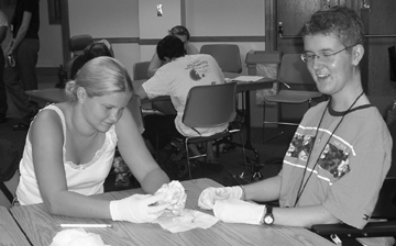 Scholars Tressa and Conrad perform surgery on a sheep heart during Summer Study '03. Picture of Tressa and Conrad performing surgery on sheep heart.