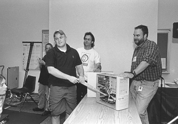 DO-IT Staff Doug Hayman and Dan Comden help Phase II Scholar Pat explore the inner workings of a PC. Picture of Pat, Doug, and Dan