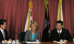 Drs. Burgstahler and Iwabuchi (at middle and right) meet with leaders at Korea Nazarene University to discuss the possibility of a Summer Study program on that campus. Picture of Drs. Burgstahler and Iwabuchi at a table in front of several flags.