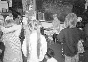 DO-IT Mentor Imke demonstrates her talking computer to kindergarten students. Picture of Imke in front of class with her computer