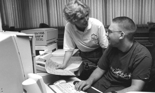 Director Sheryl Burgstahler and Ambassador Ryan, who is now a student at the University of Washington, work together on "DO-IT stuff" Picture of Director Sheryl Burgstahler and Ambassador Ryan working on a computer together.