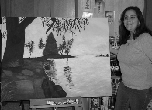 A picture of Phase II Scholar Amanda  with one of her recent paintings.