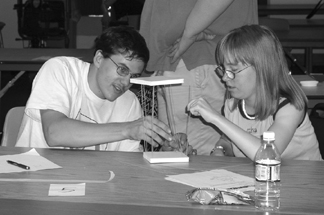 '03 Scholars Scott and Annemarie build water tower in an engineering lab during Summer Study 2003. Picture of Phase I DO-IT scholars building a water tower out of foam squares, raw spaghetti, and tape.