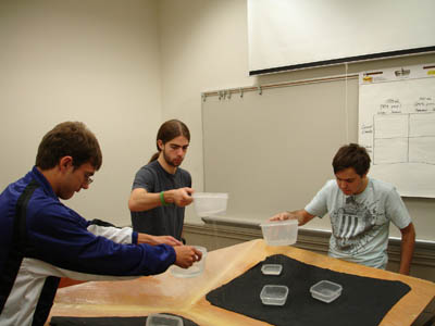 Picture of. Scott, Cory, and Peter using plastic containers of water to demonstrate climate change.