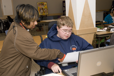 Phase I Scholar Erik and Intern Oscar work together to solve a problem during the computer lab at Summer Study. Picture of Erik working on his laptop with Oscar pointing to a handout.