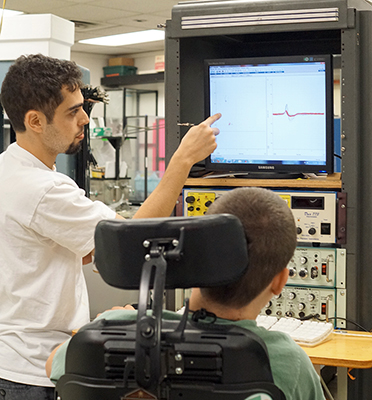 Two researchers look at data on a screen.