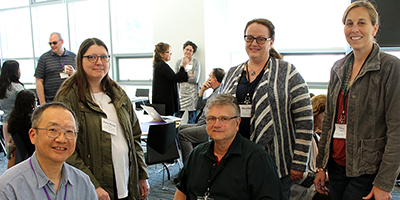 Five participants of the June 2018 Online Learning Capacity Building Institute smile for the camera.