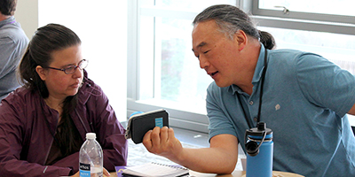 One participant shows another something on his phone.