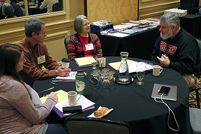 A group of participants discuss issues around the table.