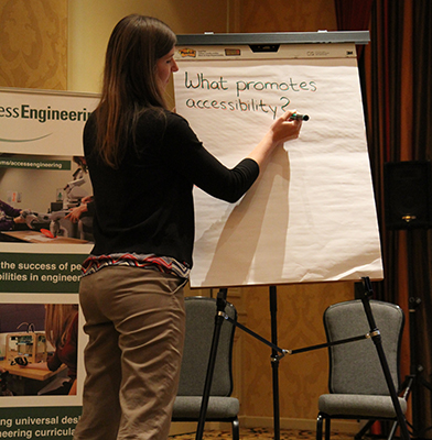 One of the presenters writing the discussion points made on a large writing board.