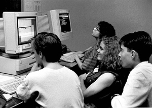 DO-IT Scholars Travis, Mitch and Katharine use a macintosh to check email while Carolyn explores the Internet with Gopher Scholars explore the internet.
