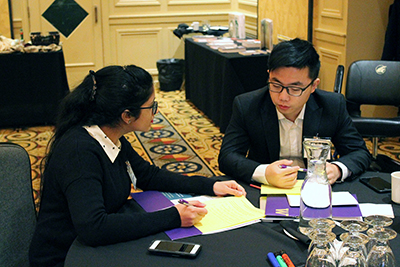 Two participants write down ideas to a discussion question.