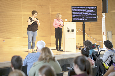 Sheryl presents while an interpreter signs.