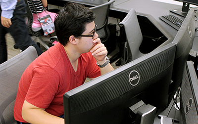 A person works on two computer monitors 