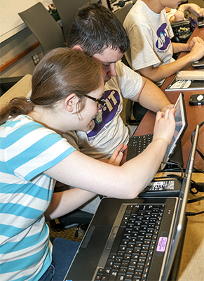 Hannah works with a classmate on a computer science project.