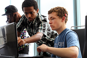 Two students working on a laptop