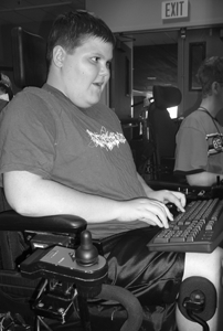 Student with a mobility impairment using a computer. Photo of student with a mobility impairment using a computer.