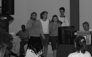 Students presenting to an audience. Image of students with disabilities at a podium speaking to an audience.