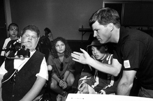 Photo of an instructor delivering information while surrounded by a group of students.