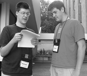 Two students looking over a set of forms. Photo of two students looking over a set of forms.