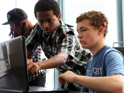 Two students view a computer screen.